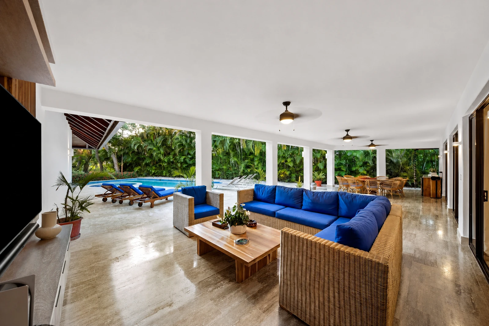 Covered lounge opening onto the private pool and tropical garden
